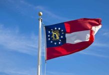 Georgia state flag waving against a blue sky