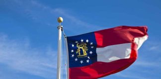 Georgia state flag waving against a blue sky