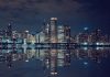 Nighttime view of a city skyline with reflections on water