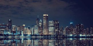Nighttime view of a city skyline with reflections on water