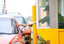 Customer receiving a food order at a drive thru window