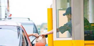 Customer receiving a food order at a drive thru window