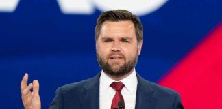 Man in a suit speaking at an event
