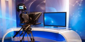 TV studio with camera and empty anchor desk