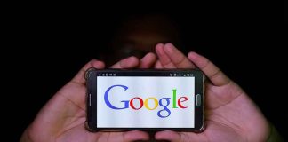 Hands holding smartphone displaying Google logo