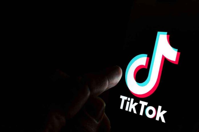 1540774727 Finger pointing at TikTok logo on a screen