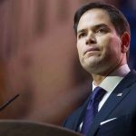 Man in suit speaking at podium