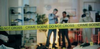 Crime scene with tape and investigators examining evidence