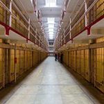 Long hallway with prison cells on both sides