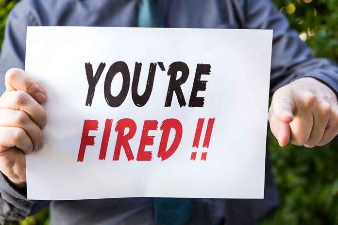 Person holding YOURE FIRED sign