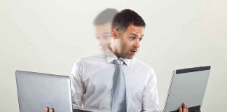 Man holding two laptops and looking surprised