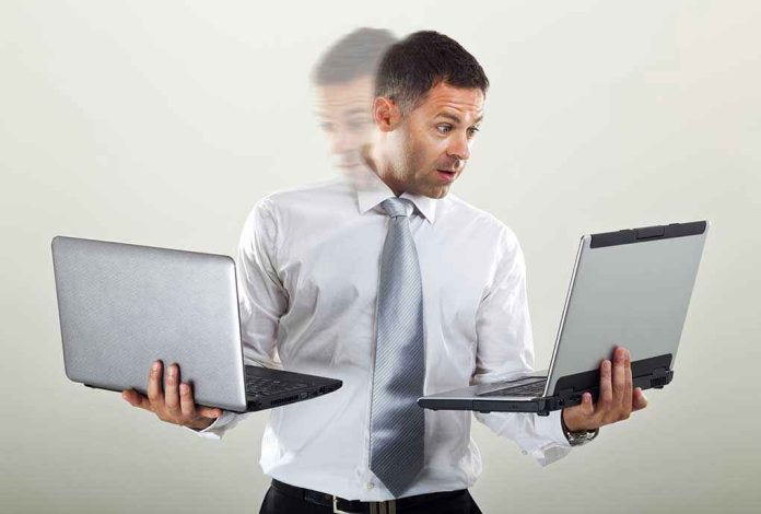 Man holding two laptops and looking surprised