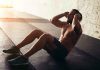 Man performing sit ups in a gym setting