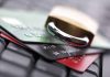 A padlock resting on top of multiple credit cards on a keyboard