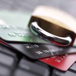 A padlock resting on top of multiple credit cards on a keyboard