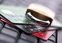 A padlock resting on top of multiple credit cards on a keyboard