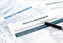 Close-up of health insurance application forms with a pen