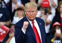 Man in suit making a fist gesture at rally