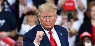 Man in suit making a fist gesture at rally