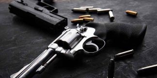 Revolvers and bullets on a dark surface