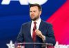 JD Vance’s SHOCKING Rise Terrifies Democrats Man speaking at a podium wearing suit and tie