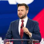 JD Vance’s SHOCKING Rise Terrifies Democrats Man speaking at a podium wearing suit and tie