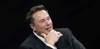 Man in suit smiling resting chin on hand