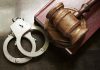 Infant Abandoned—Exec Couple Under Fire! Handcuffs beside a gavel on a book