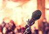 Close up of microphone with blurred audience background