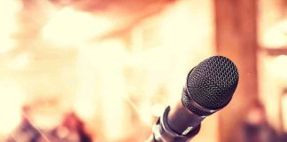 Close up of microphone with blurred audience background