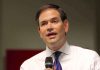 Rubio BETRAYS US Informants in Shocking Deal Man in white shirt speaking into a microphone.