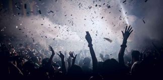 Anti-American Concert Sparks Conservative Outrage Crowd celebrating under confetti and bright lights.