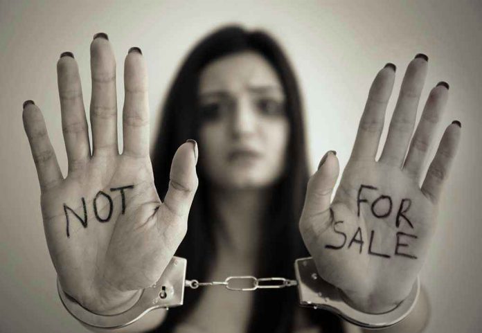 631031339 Handcuffed woman shows NOT FOR SALE on her palms
