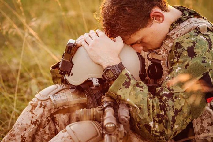 Soldier sitting leaning head on helmet