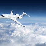 Private jet flying above the clouds