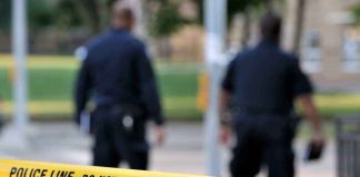 Deadly Swatting Rampage—Cops Missed Every Sign Police officers walking past caution tape at a crime scene