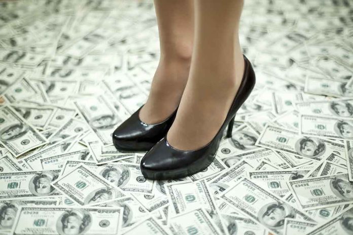 shutterstock_203119678.jpg A pair of black high heels standing on a floor covered with dollar bills