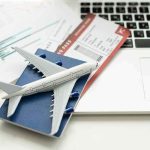 Biometric ID Shock: Travelers Forced Into New System A model airplane on a blue passport next to a laptop and boarding pass