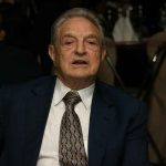 Soros’ $7.6M Protest Plan Backfires Elderly man in a suit sitting at a dining table during a formal event