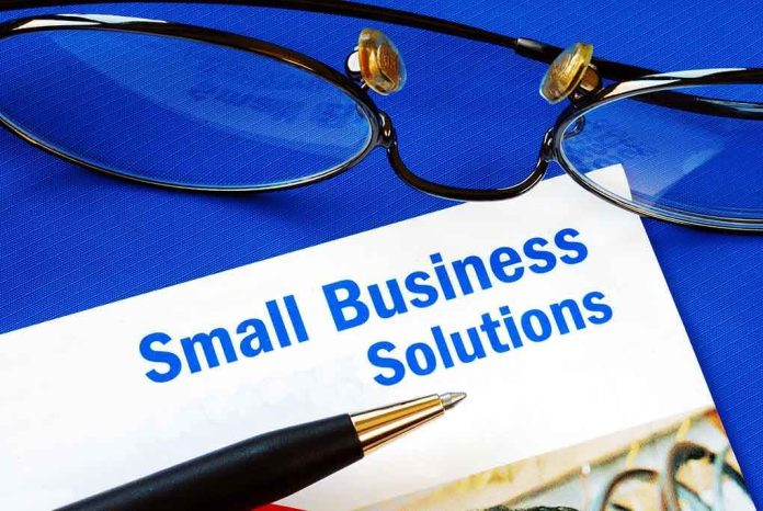 Close up of glasses and a pen resting on a document titled Small Business Solutions