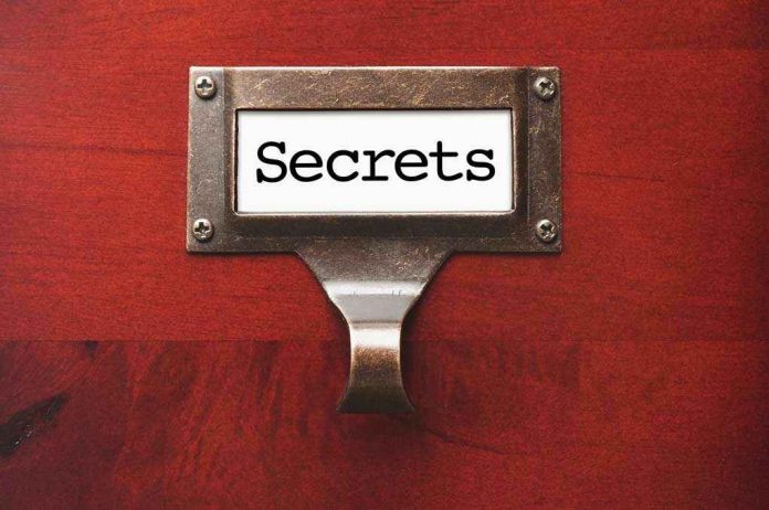 106336844 Metal label holder saying Secrets on wood background