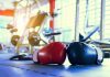 Boxing gloves on gym floor with equipment