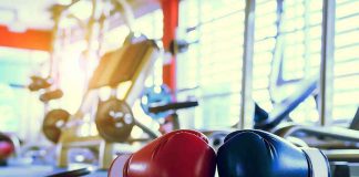 Boxing gloves on gym floor with equipment