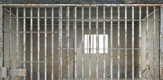 Empty rusty prison cell with a small window.
