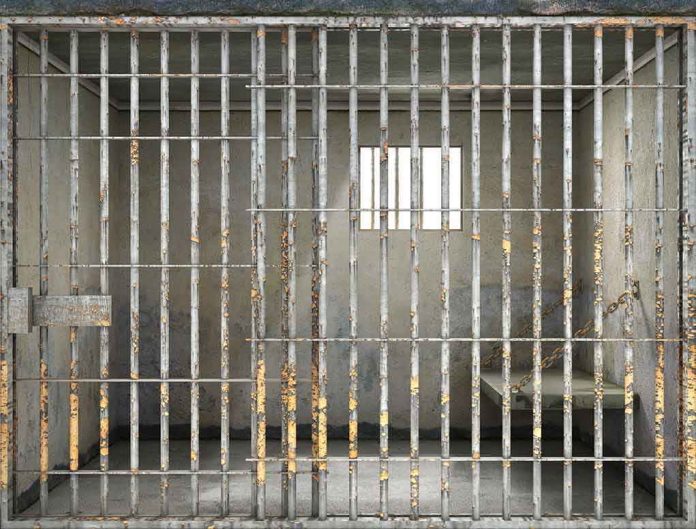 Empty rusty prison cell with a small window.