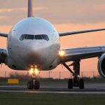 Airplane on runway during sunset.