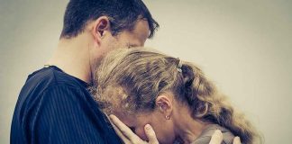 A couple embracing, with one partner comforting the other who is in distress