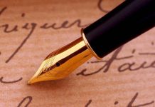 Close-up of a gold nib fountain pen resting on handwritten notes