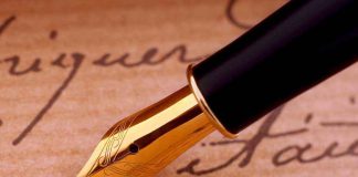Close-up of a gold nib fountain pen resting on handwritten notes