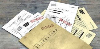 Classified documents with Top Secret stamps on wooden surface.